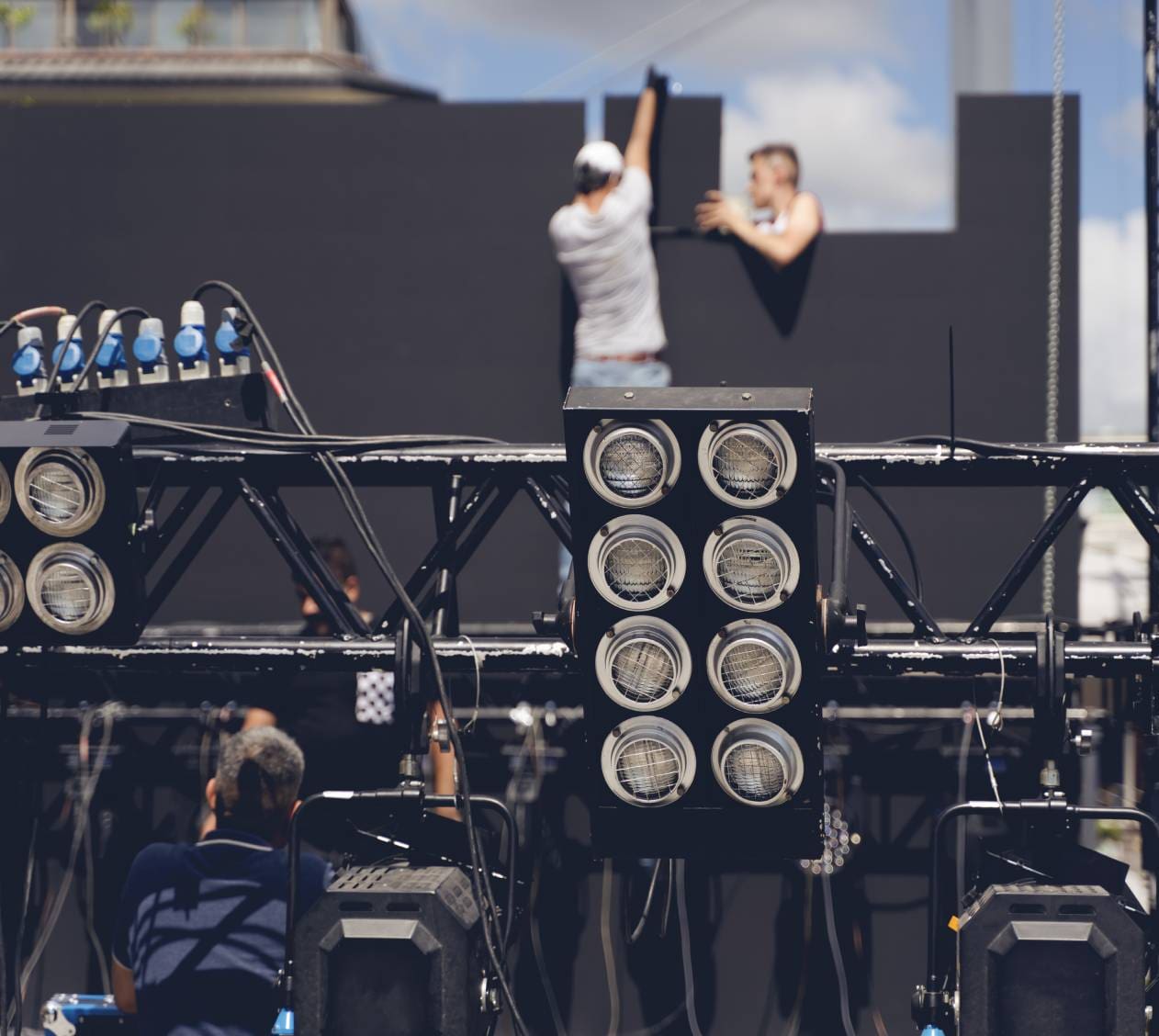 Stage lights with blurred background workers.